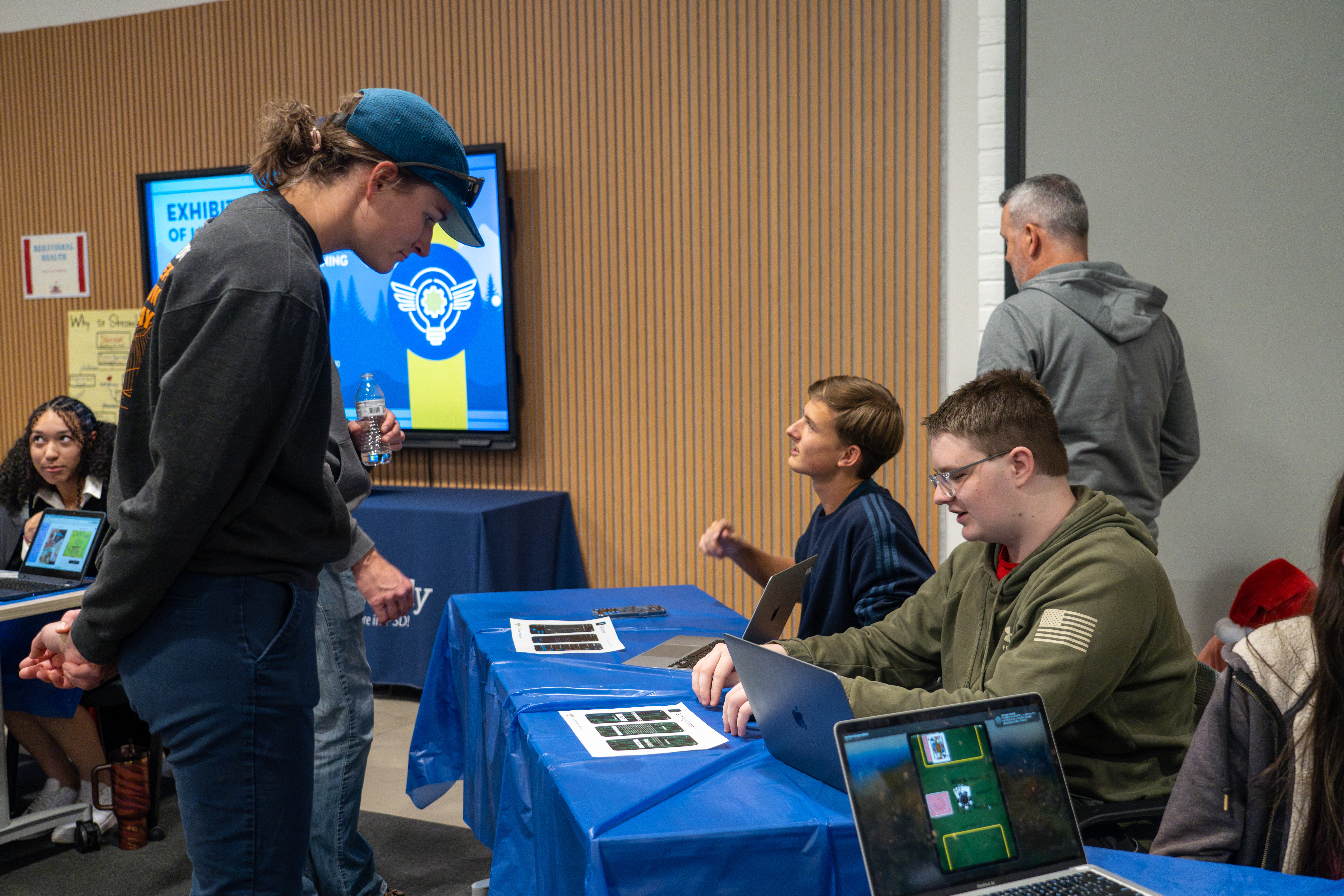 A person at the Exhibition of Learning examines a student project. 
