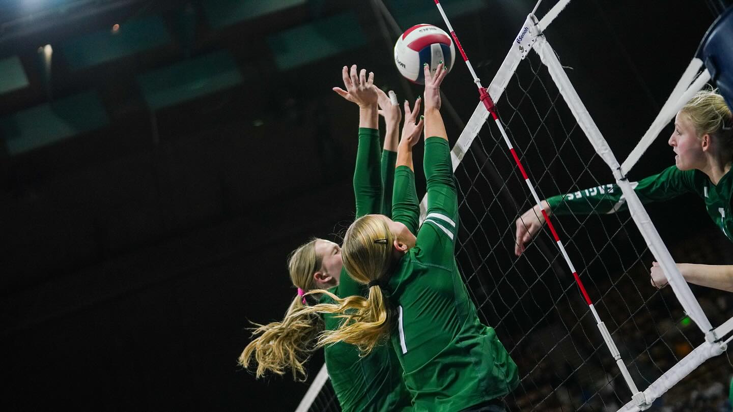 Two Volleyball Players blocking a volleyball
