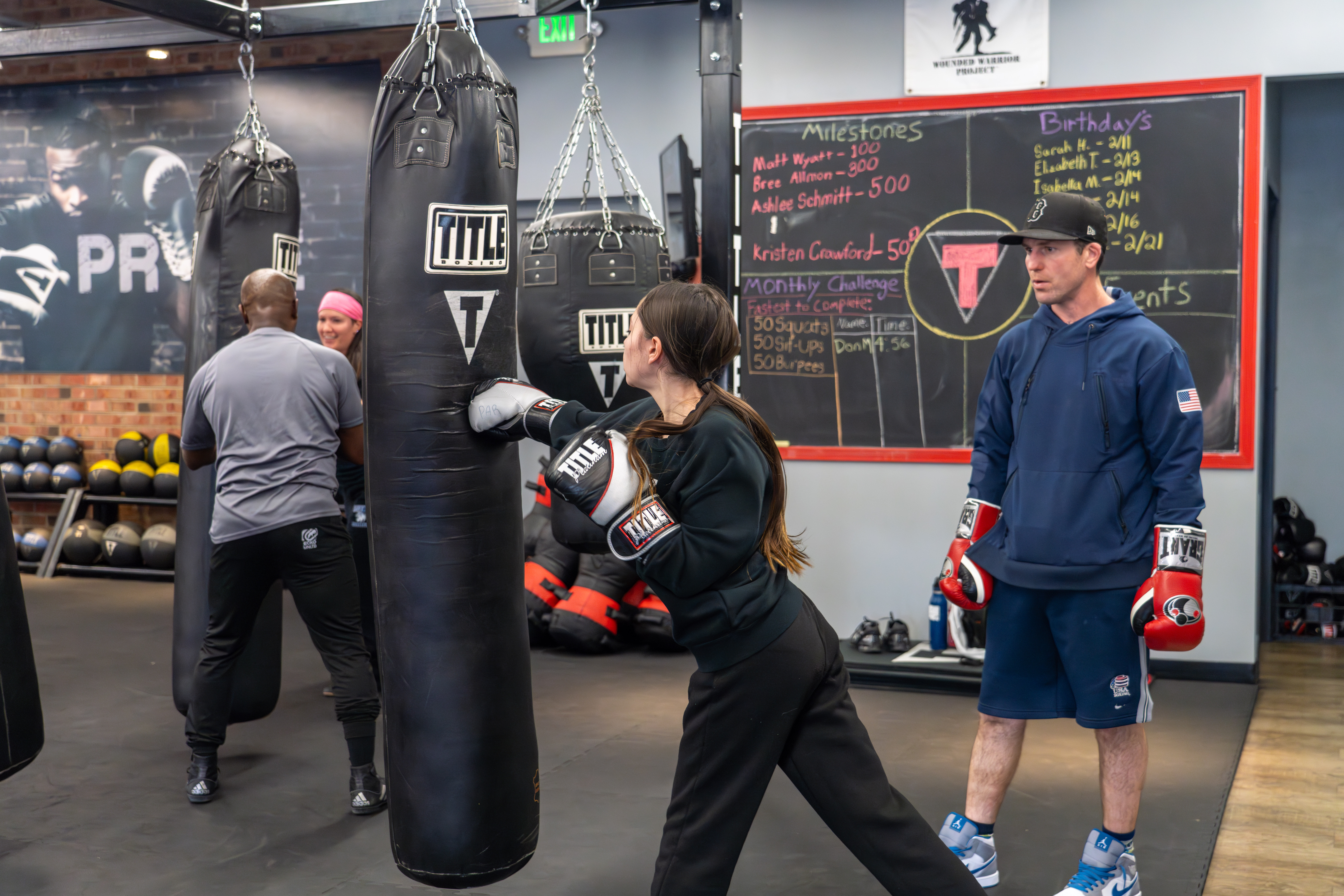 Boxing coaches work with students.