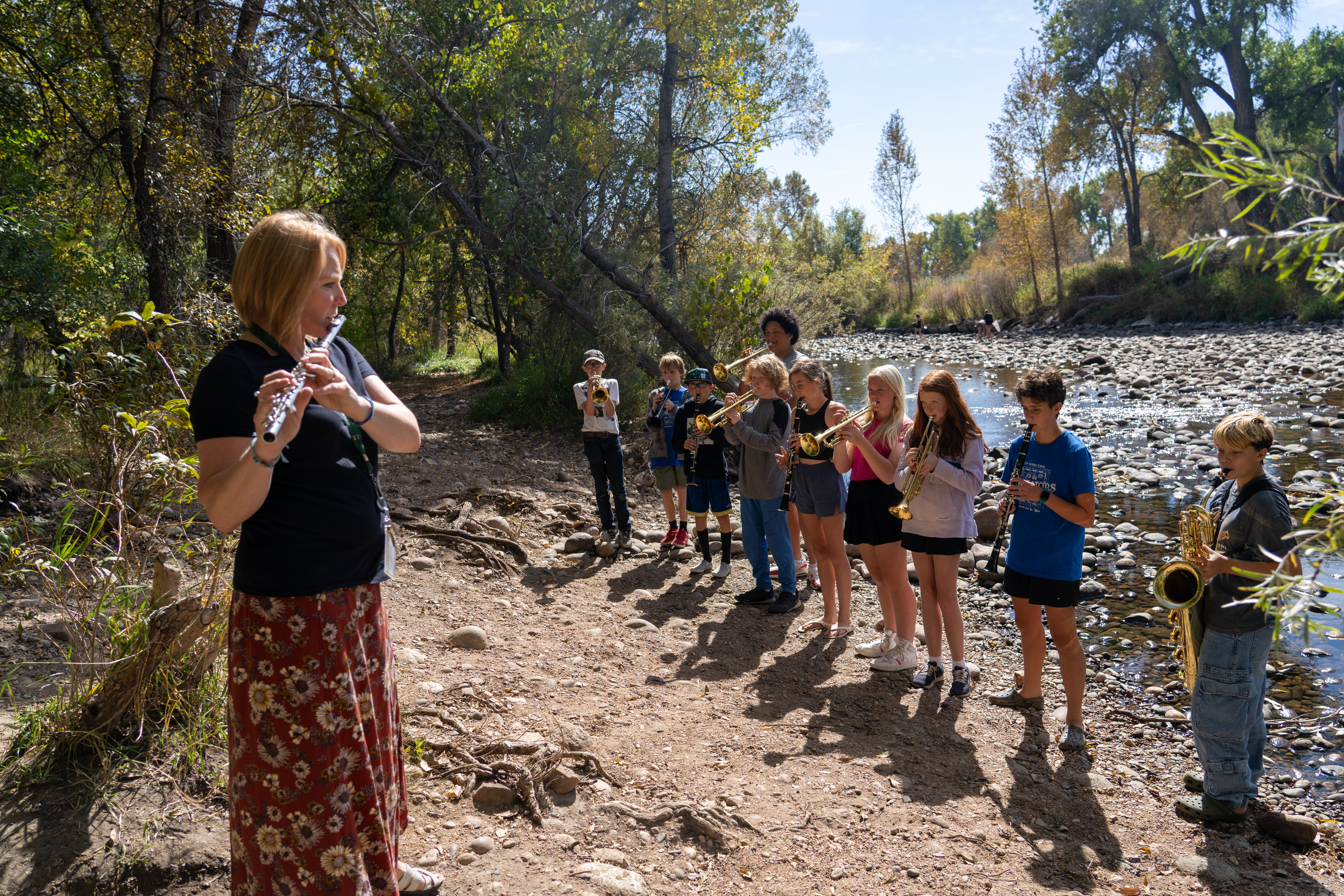 Students play musical instruments by the river during River Week. 