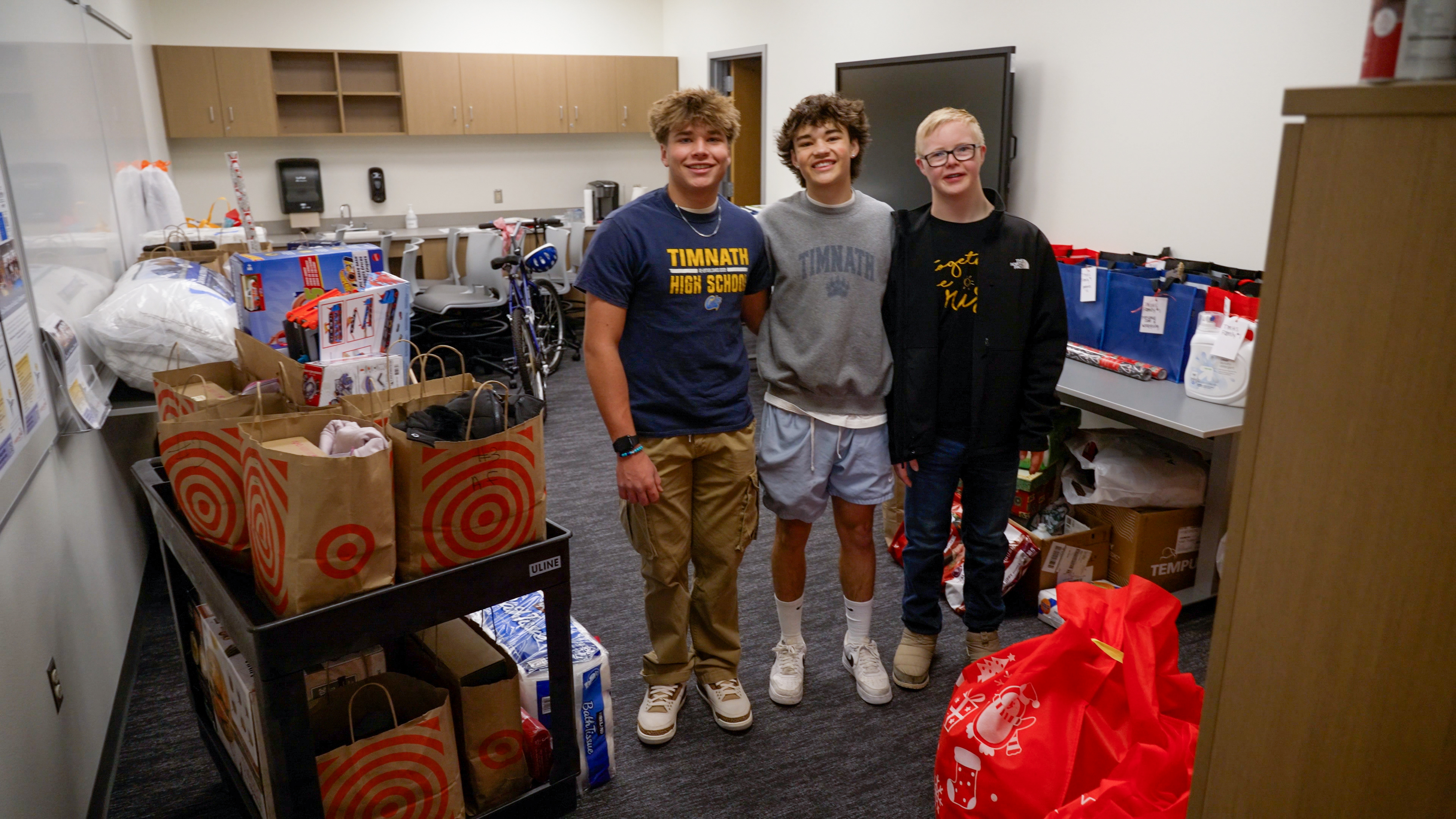 Students stand with gifts they collected for their Adopt A Family program.