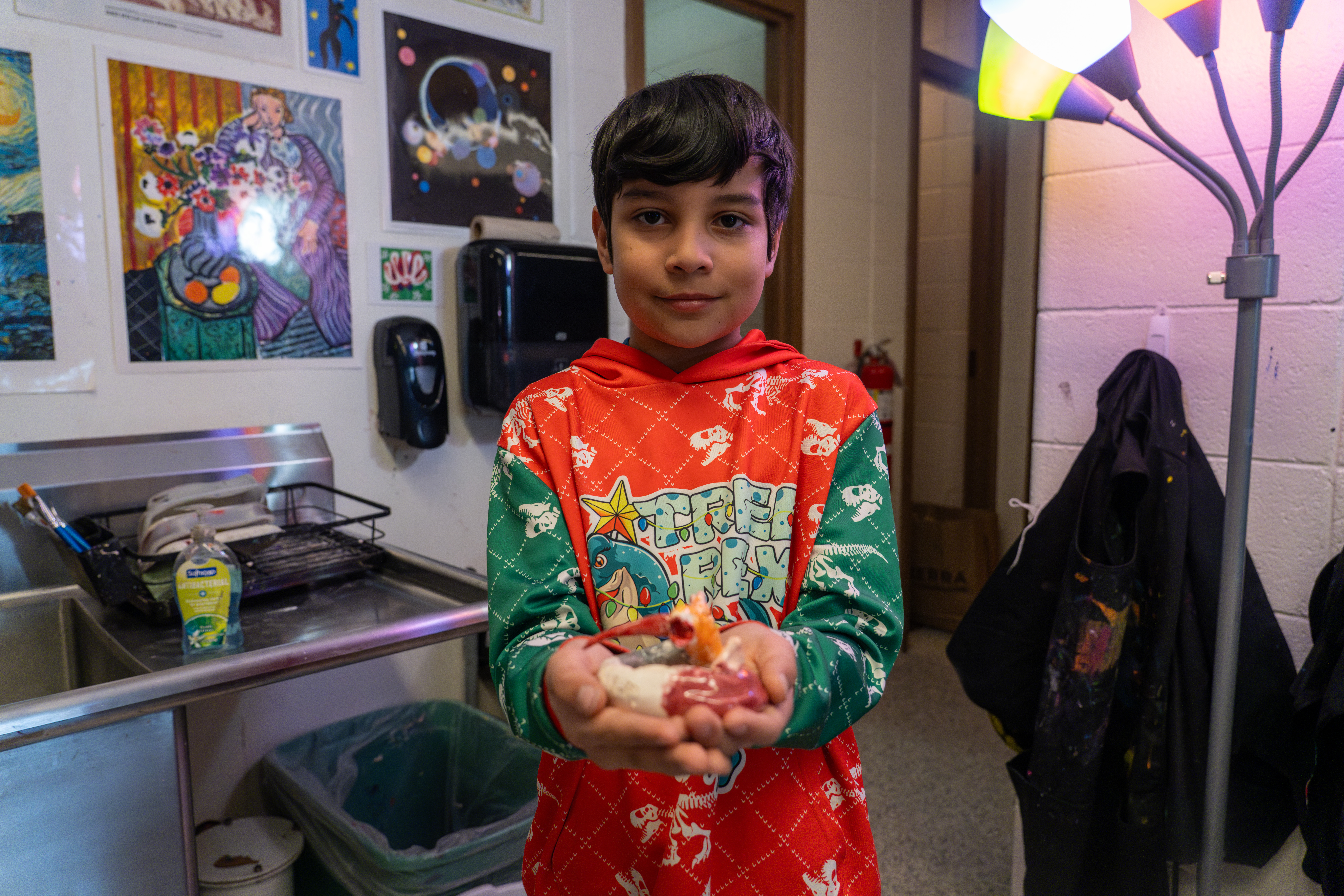 A Bauder student shows off his art project.