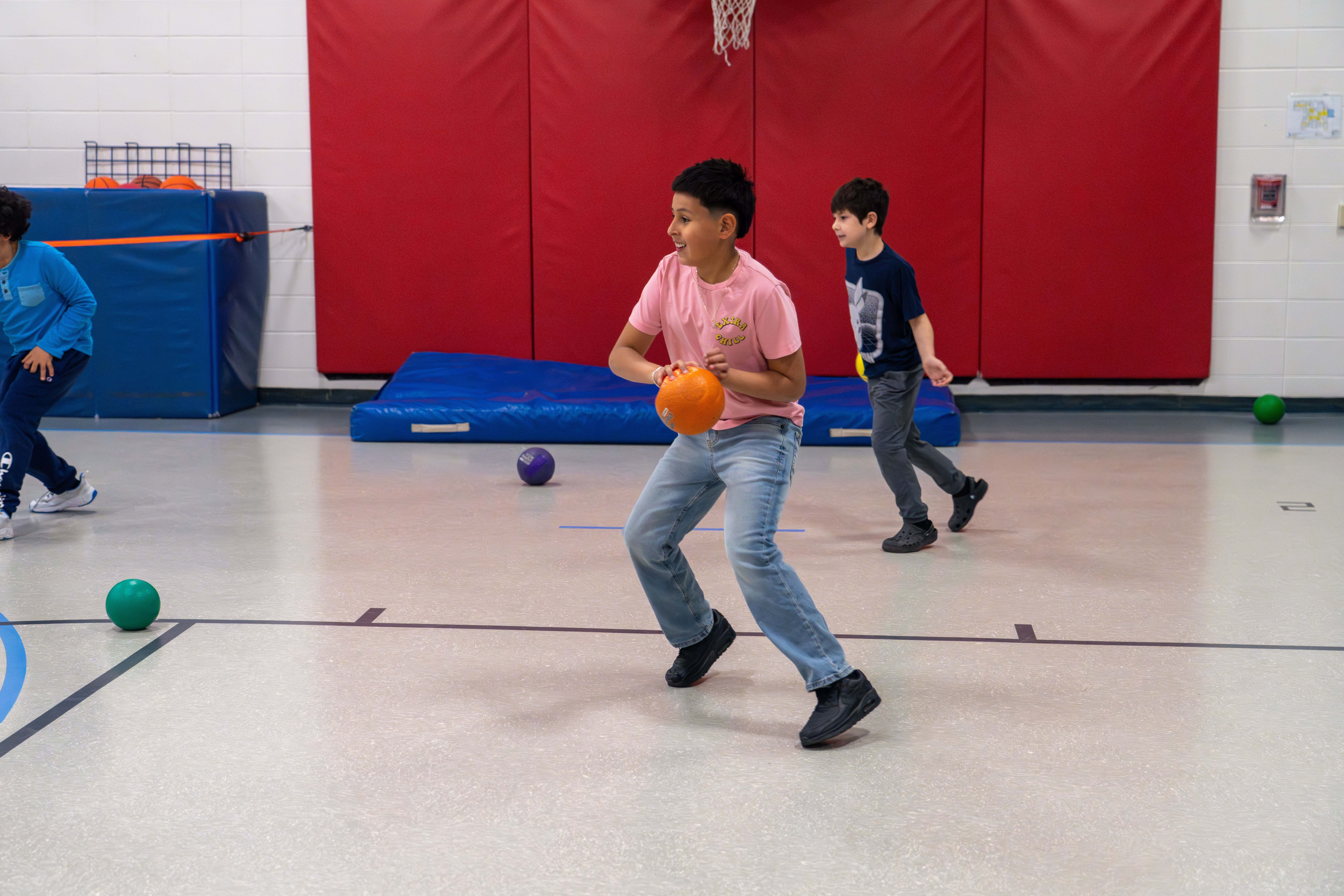 A Bauder Elementary student plays ball in a gym. 