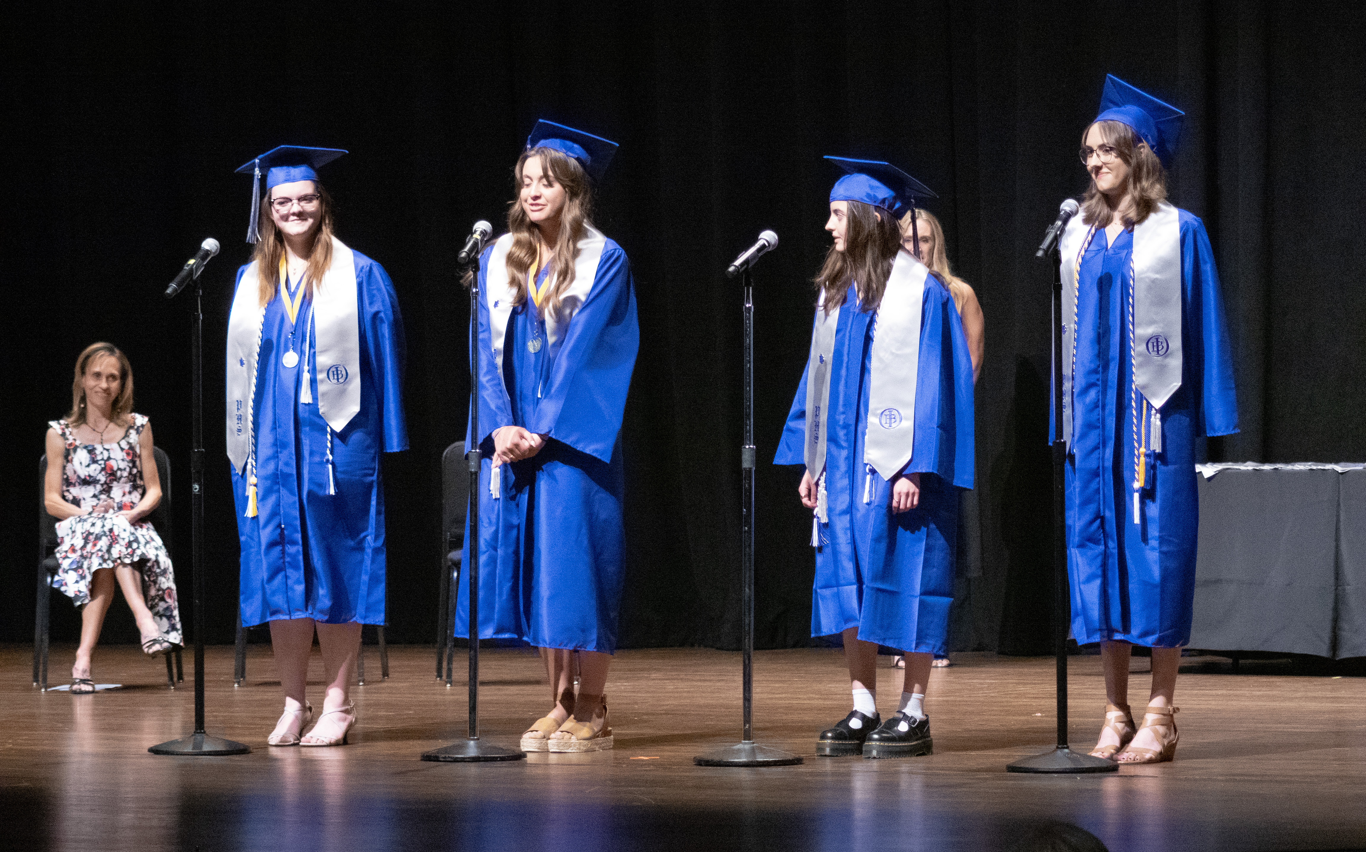 Four Poudre High School IB grads on stage to speak. 