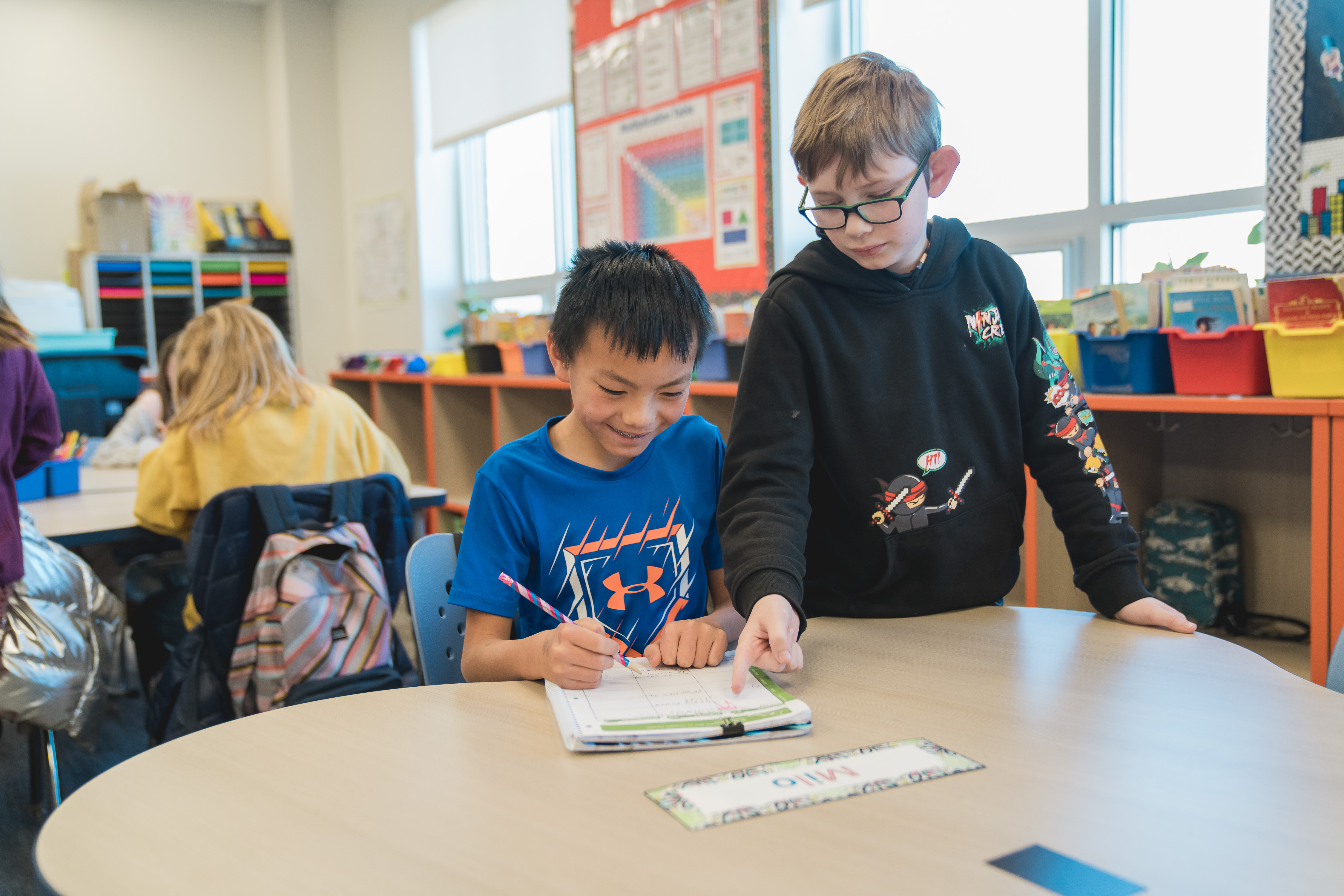 Two boys in elementary school work together at a table. 