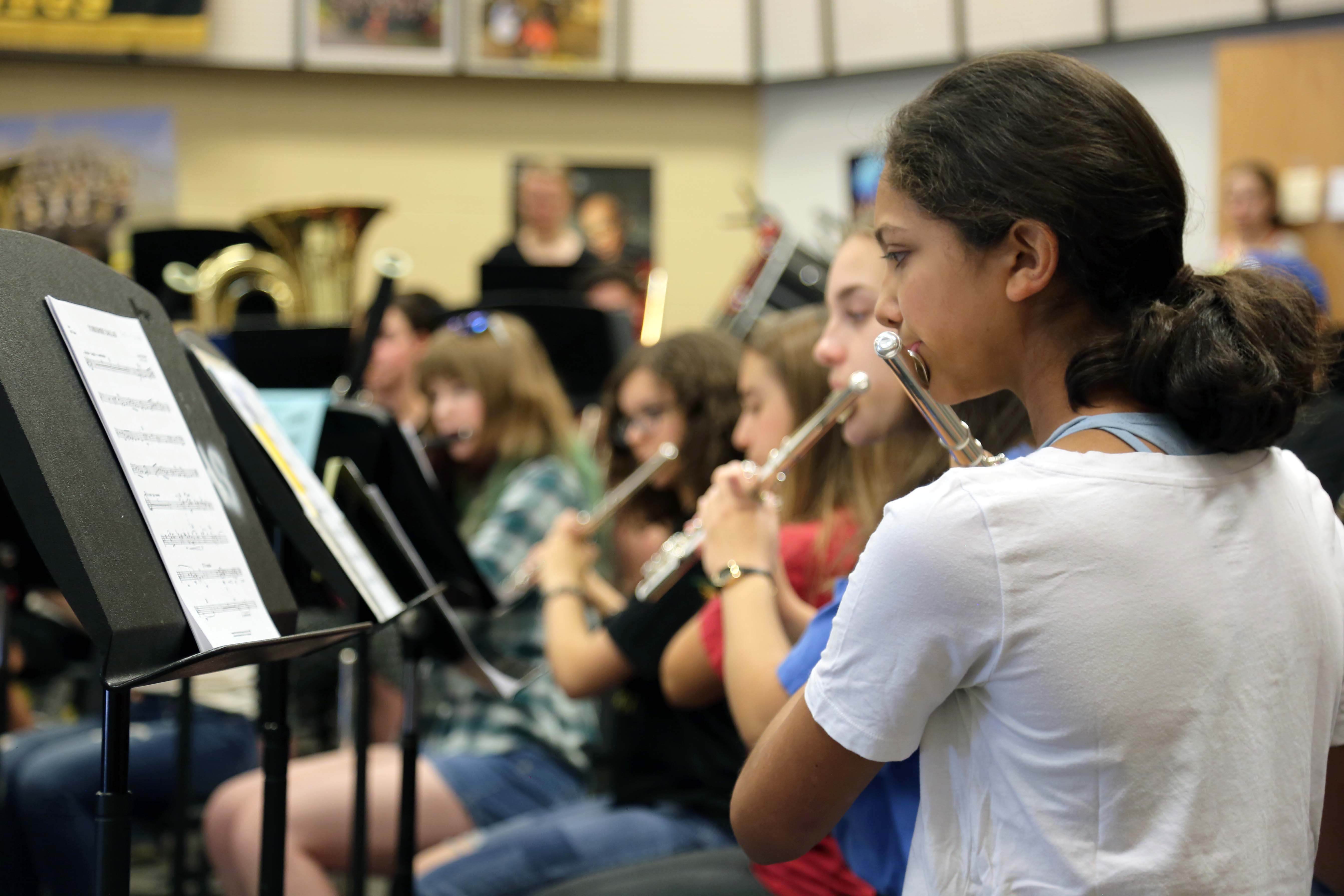 A flute player looks at her sheet music.