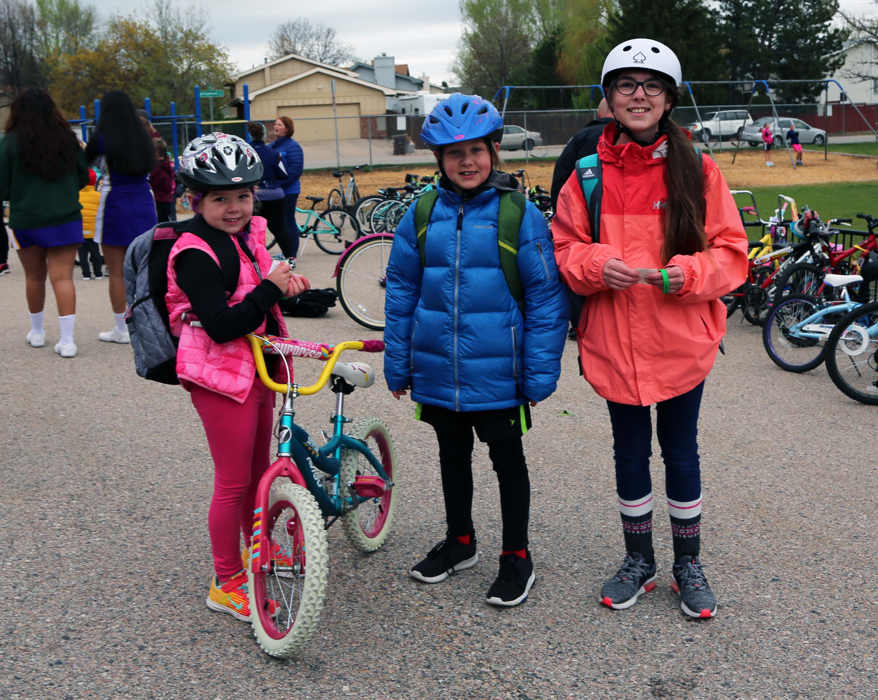 Three girls stand with their bikes on Bike to School Day.