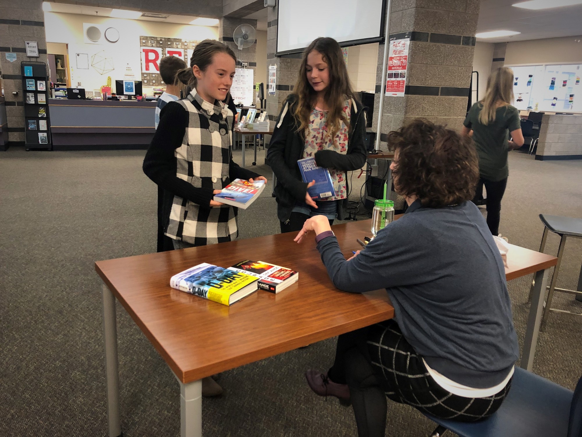 Two Webber Middle School girls visit with author Deborah Hopkinson.