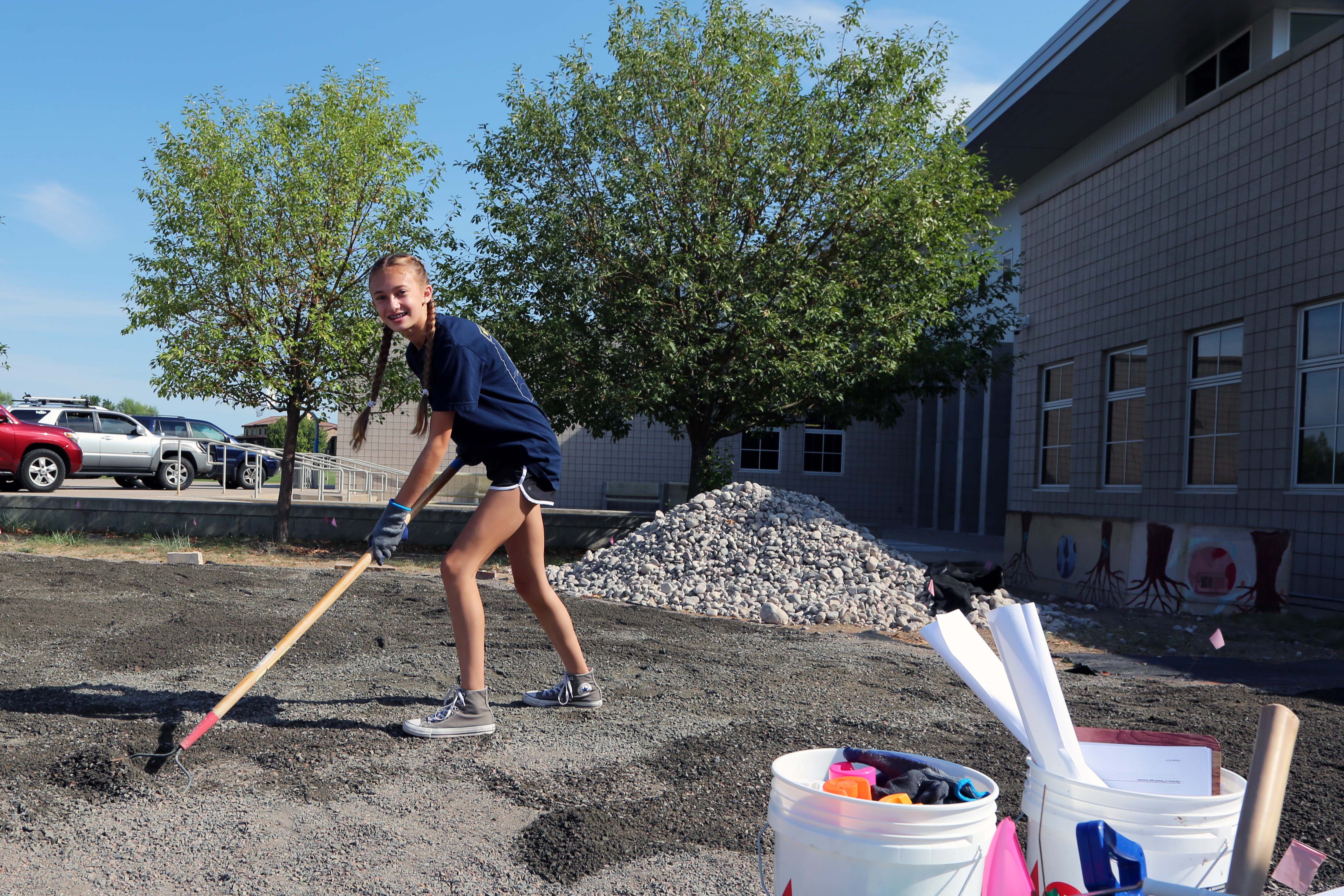 A middle school girl helps by shoveling dirt at the Outdoor Learning Classroom at Kinard Middle School.