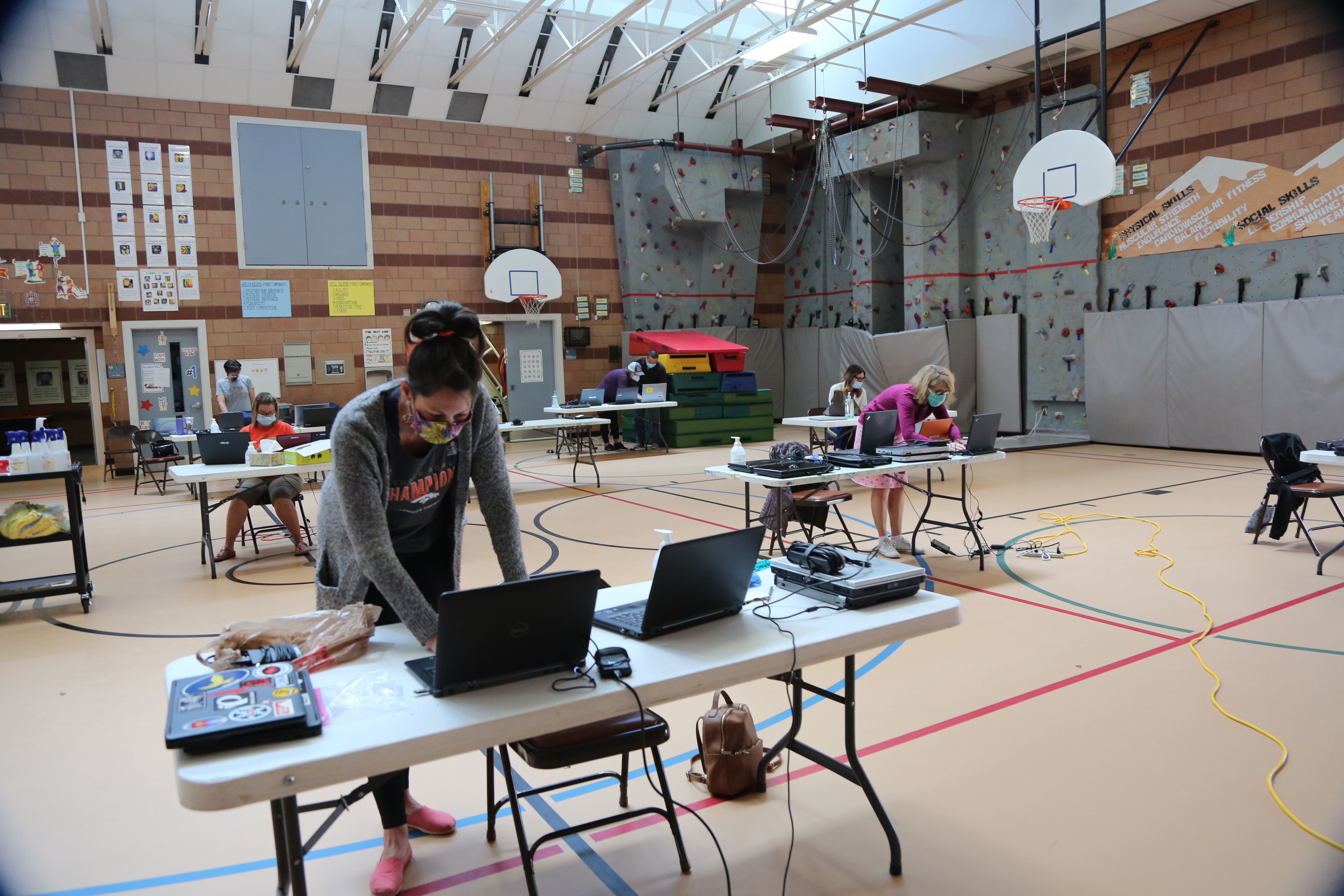 Staff work on donated laptops in the gym at Olander Elementary. 