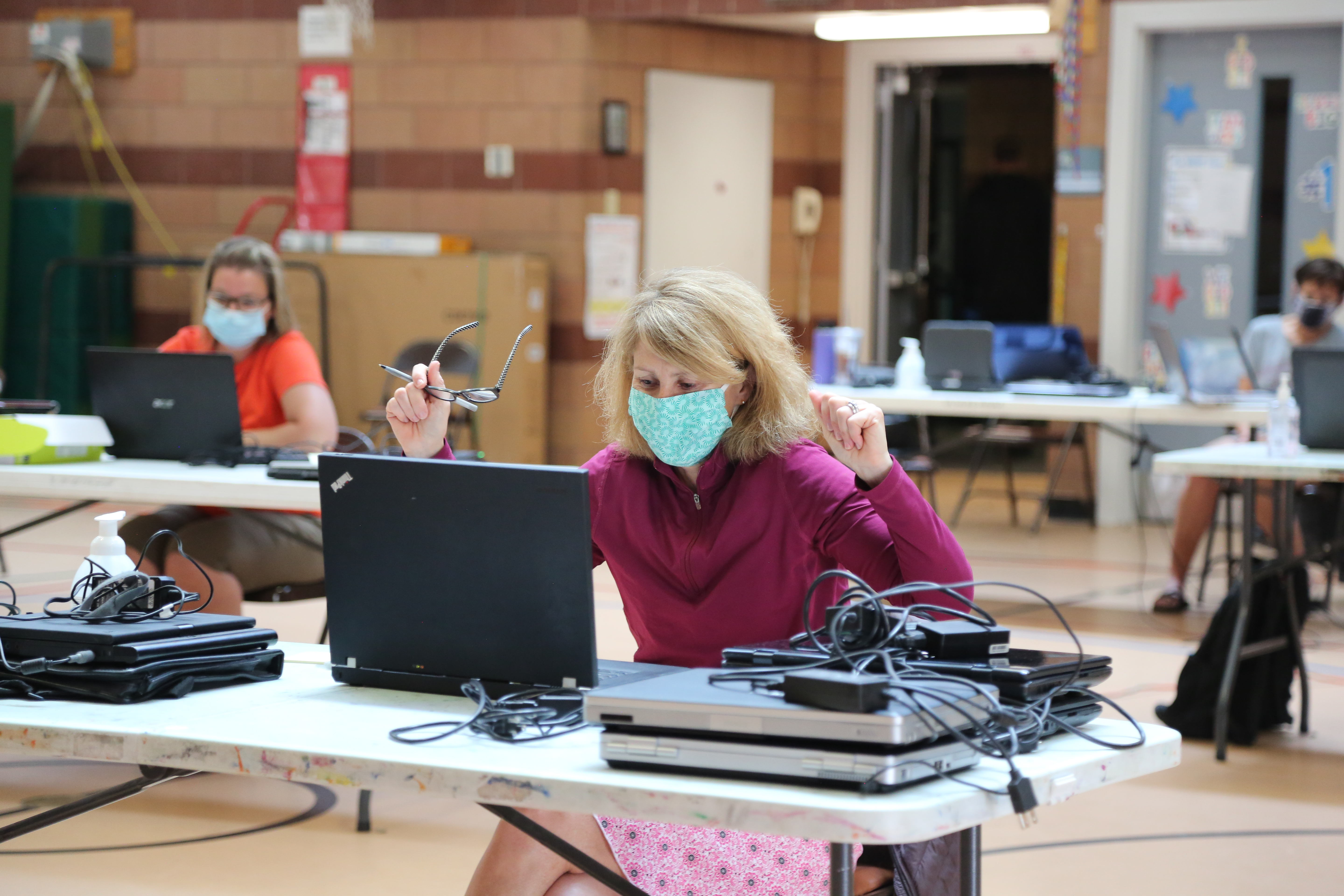 A staff person cheers after working on a donated laptop at Olander. 