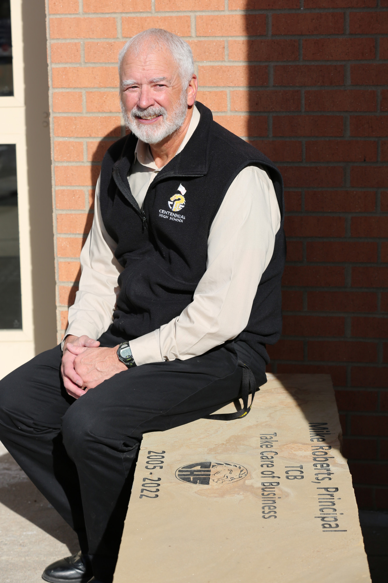 Centennial High School principal Mike Roberts sits on a bench dedicated in his honor.