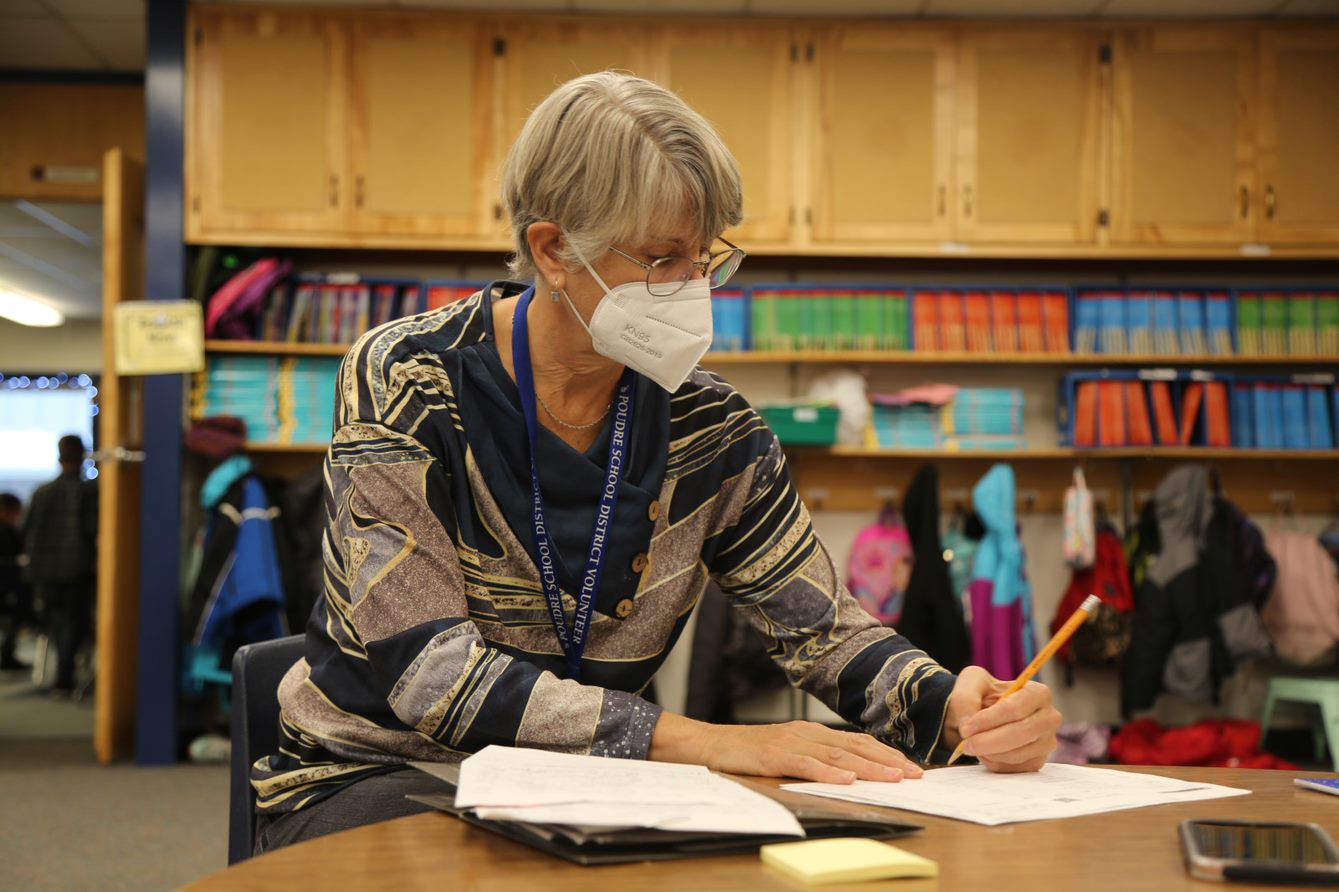 Irish Elementary volunteer Nancy Hazelrigg organizes materials at a desk. 