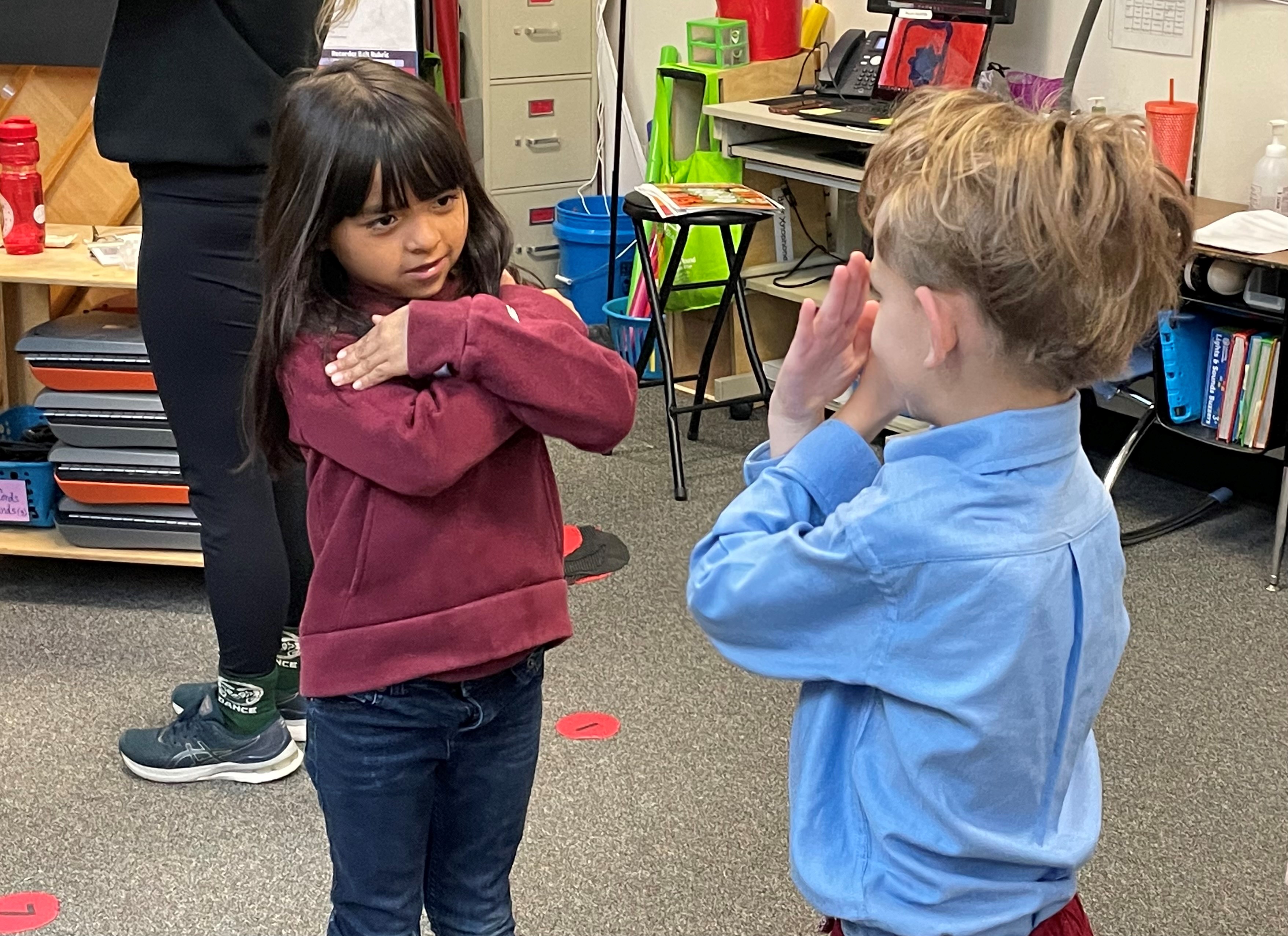 Two elementary students dance together.