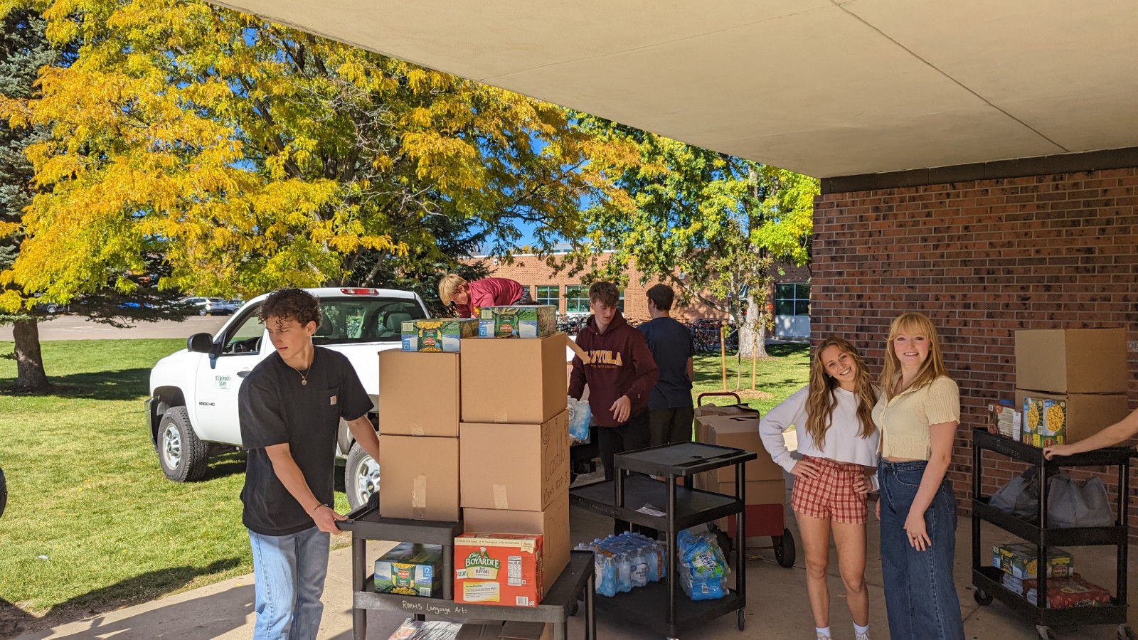 Rocky Mountain High School students load up boxes of canned goods in vehicles for CSU CANS Around the Oval.