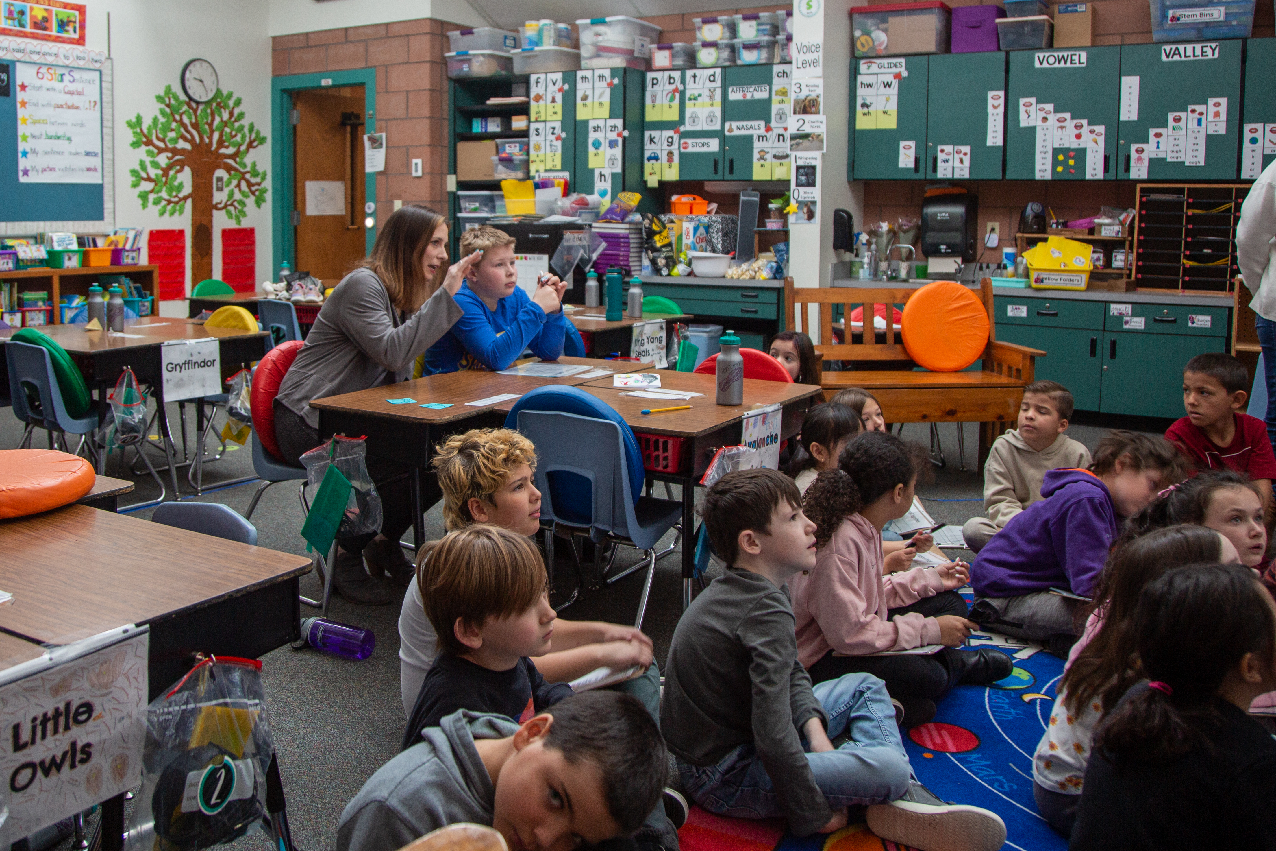 Amanda Pawelski, assistant principal, sits with a student in class.