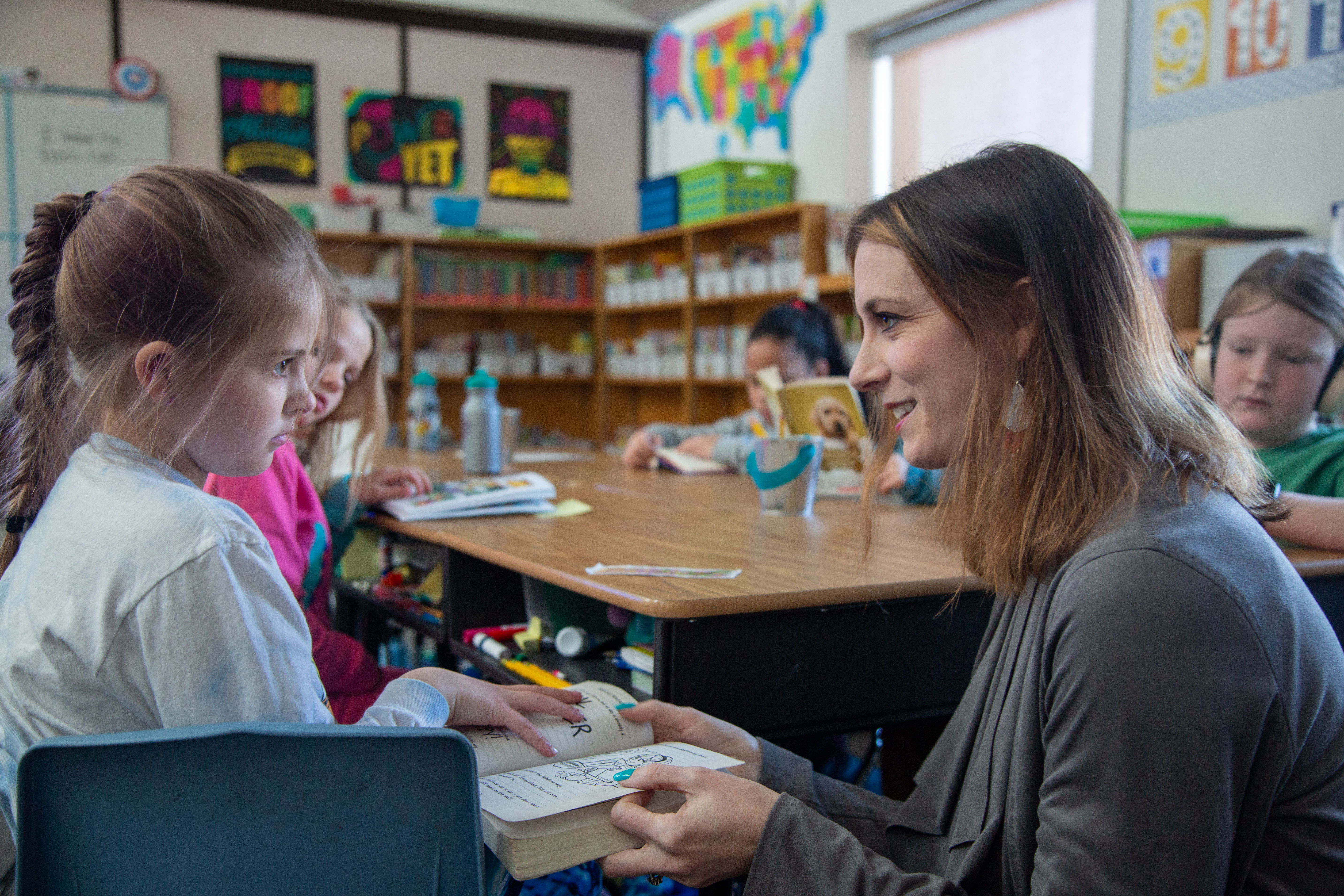 Amanda Pawelski, assistant principal, talks with a student in a classroom. 