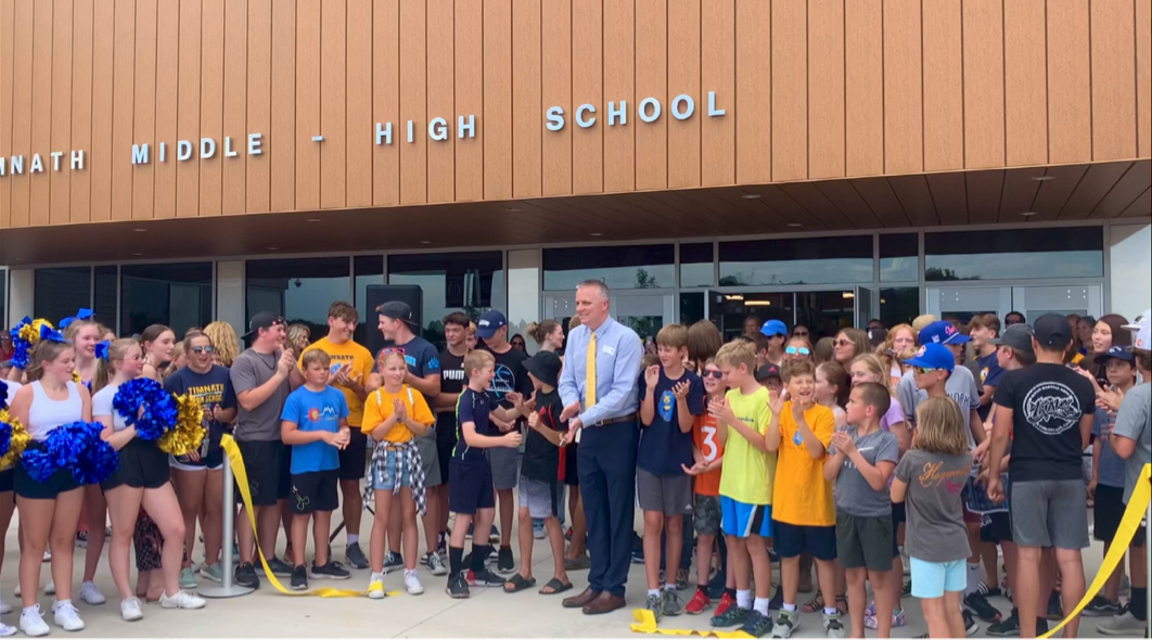 Students help cut the ribbon during the new school celebration. 