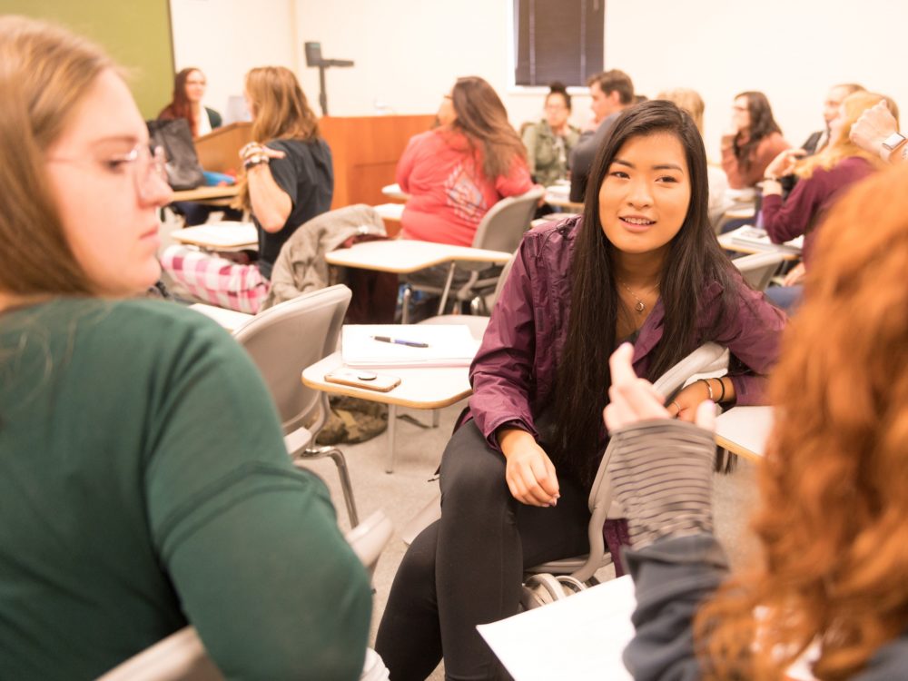 Colorado State University students talk with each other.