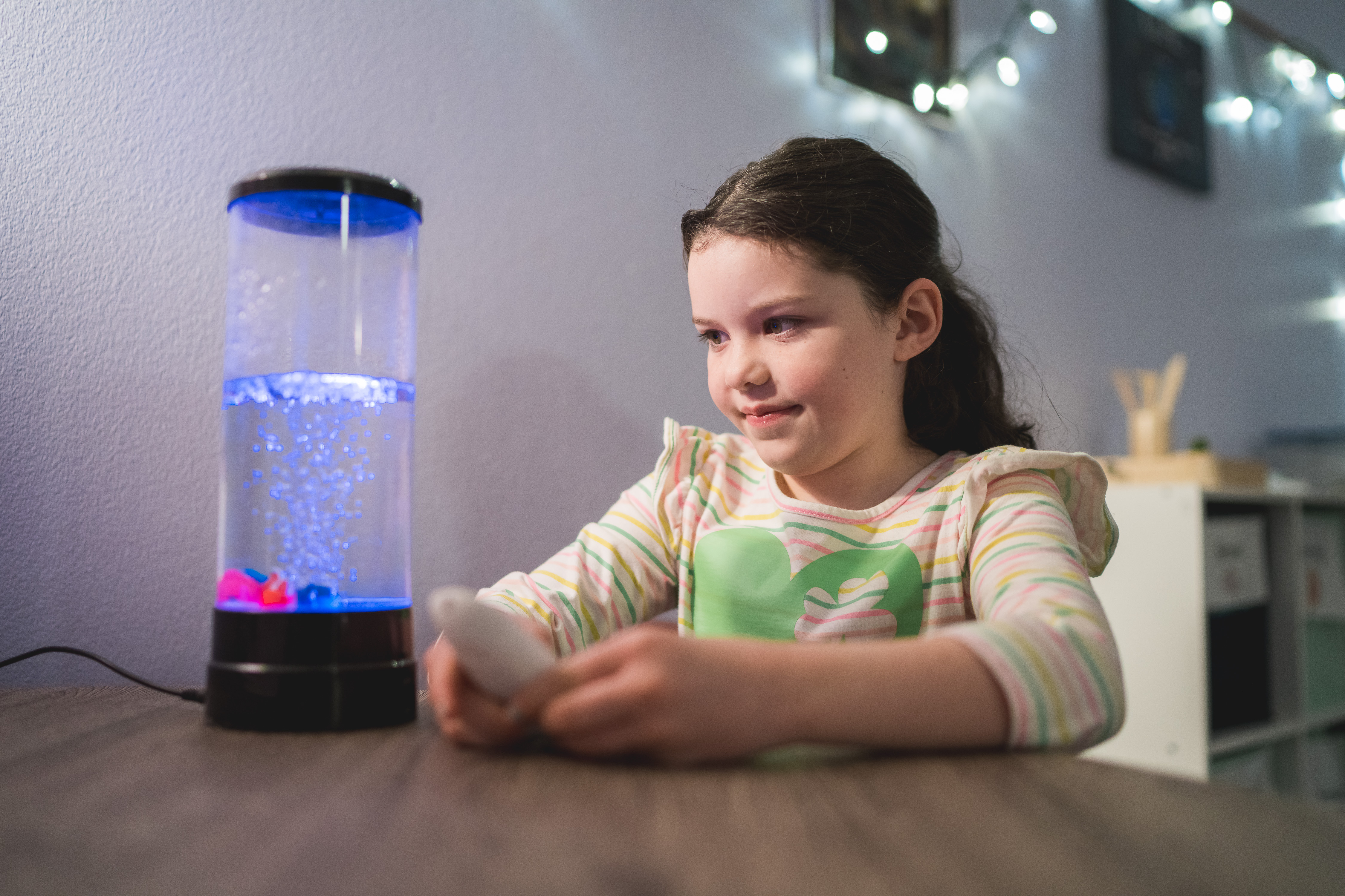 A young girl tries a sensory calming technique by looking at bubbles.