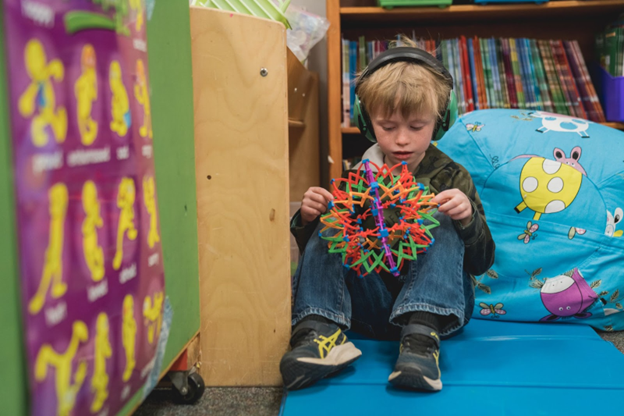 A young boy relaxes in a calming corner at Cache La Poudre Elementary School.