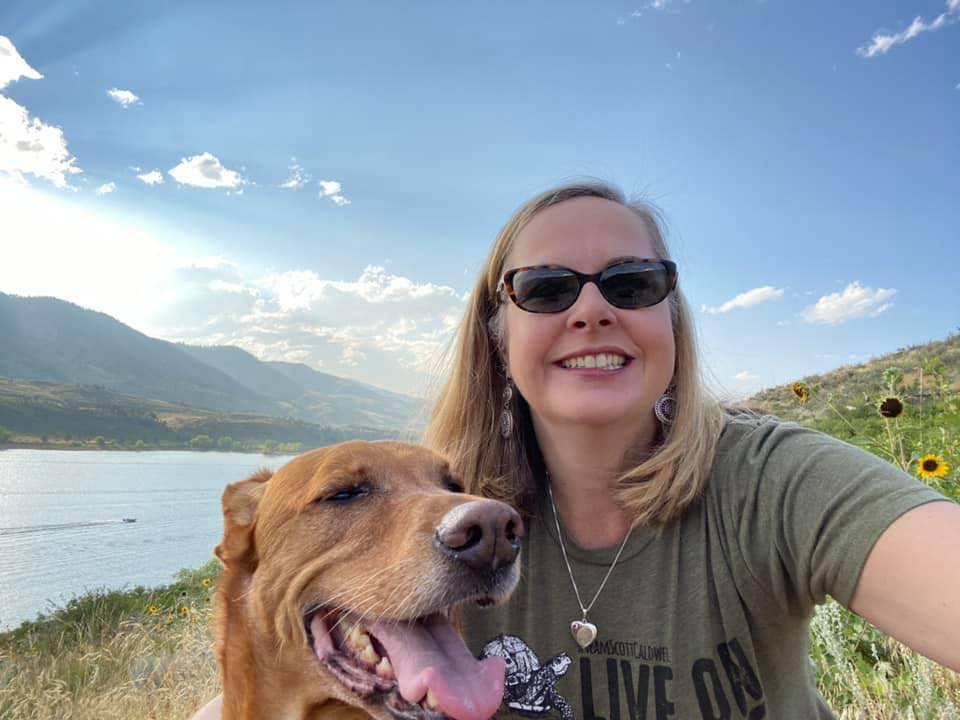 Kim Granger smiles with her dog Simon outside.