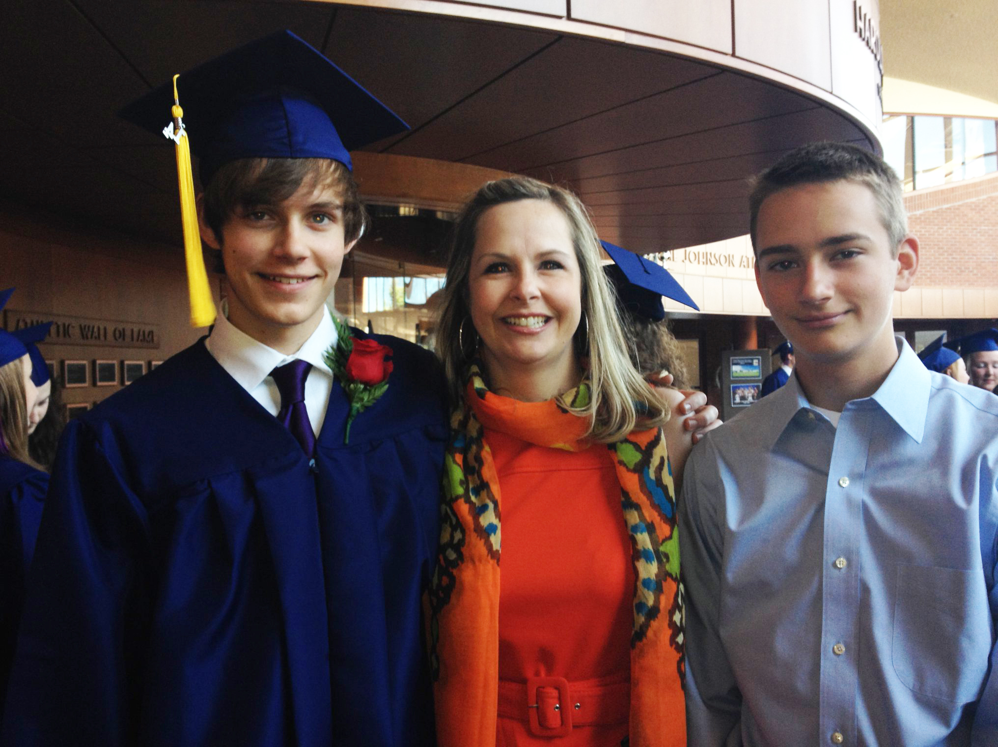 Robbie Granger with a graduation cap stands next to his mother Kim Granger and brother.