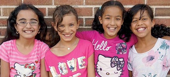 Elementary students smiling at the camera.