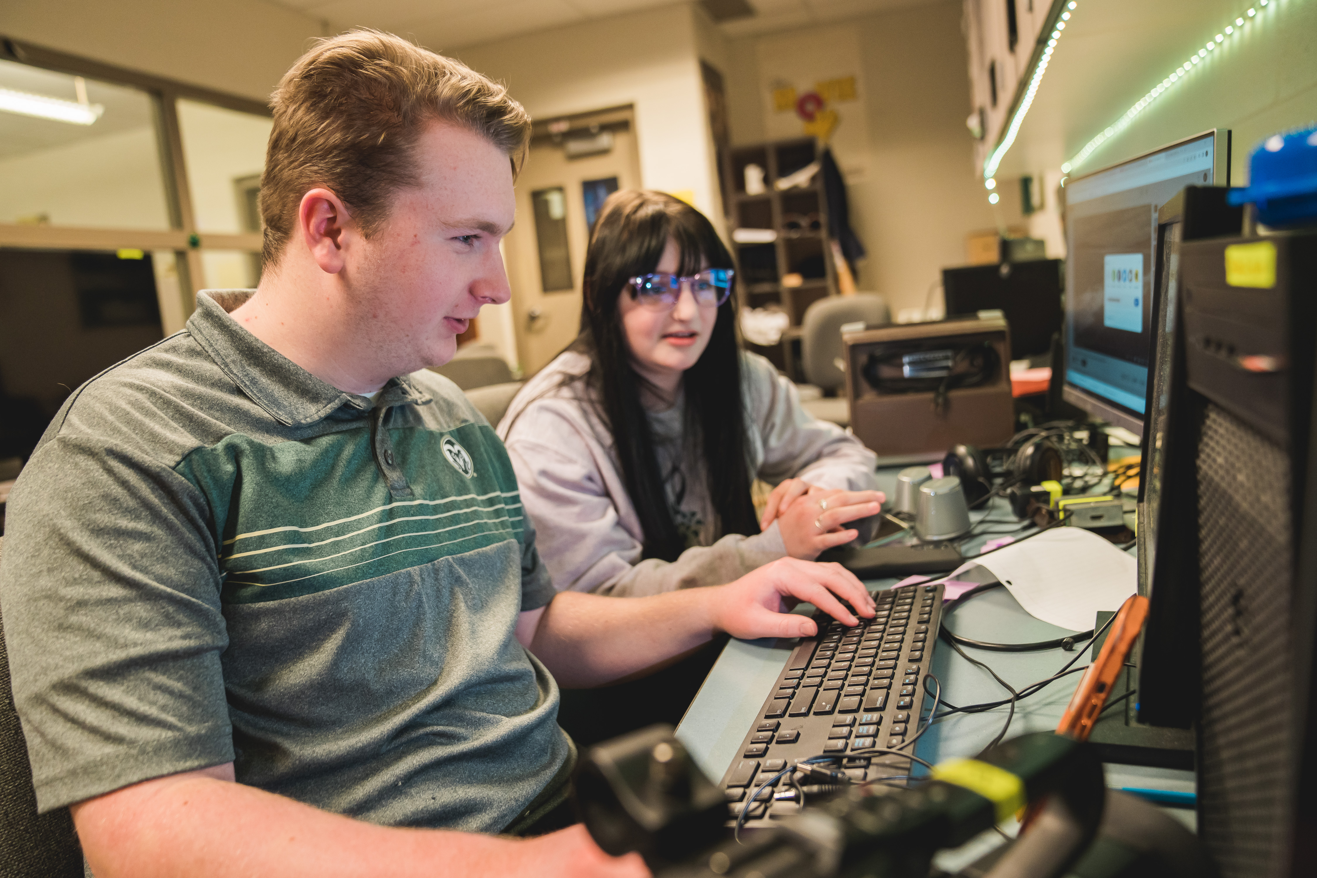 Two high school students work at a computer.