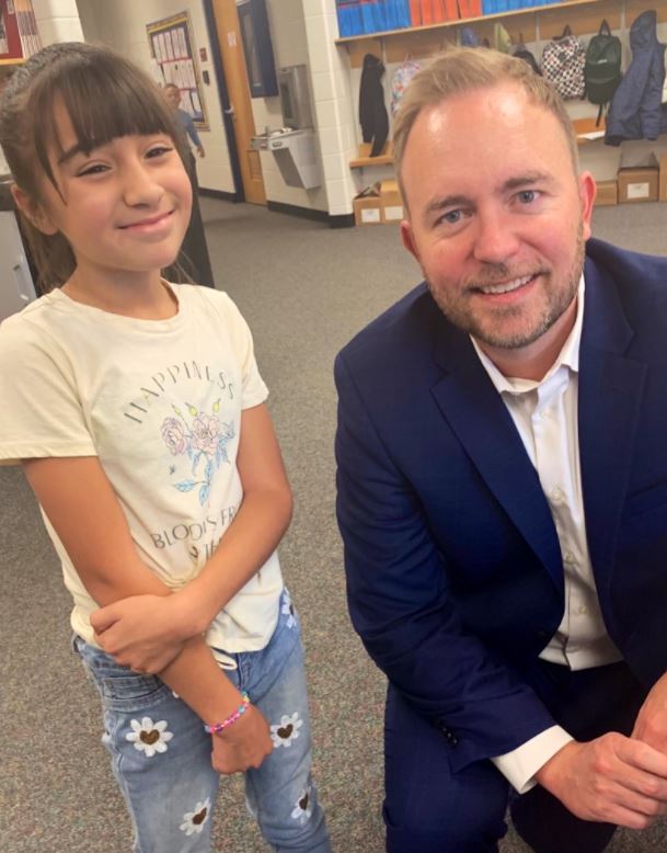 Brian Kingsley with Irish Elementary student Bianca in the school hallway.