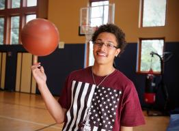 Boy in the gym with a basketball.