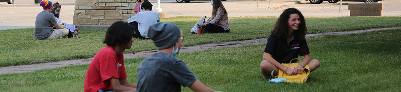 High School kids sitting outside on the lawn of Poudre High School.