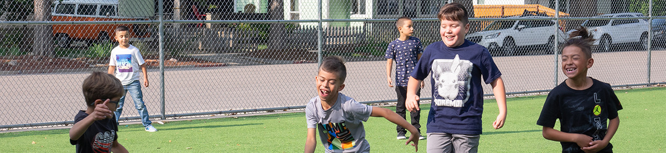 Young boys playing soccer at a school.