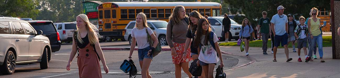 Middle school students walking outside a school.