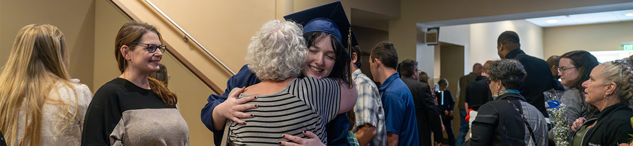 A graduate hugs a family member.