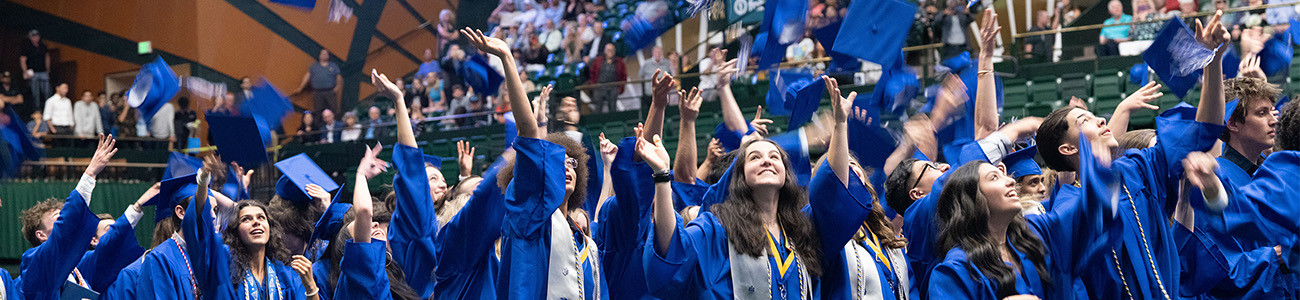 2024 Poudre High School grads throw caps in the air.