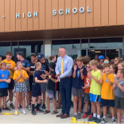 TMHS Principal Jesse Morrill with kids cut a ribbon to mark the opening of the school. 