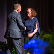 The superintendent congratulates a staff award winner.