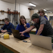 A Poudre High School volunteer works with students in a robotics class. 