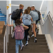 Students with backpacks walking up the stairs.
