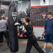 Boxing coaches work with students.