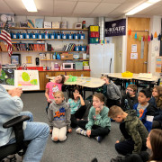 A PSD volunteer reads to students. 