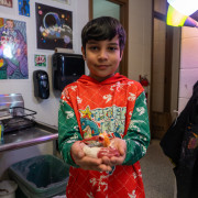 A Bauder student shows off his art project.