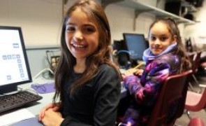 student smiling while at a computer