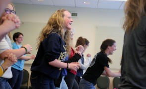 Students dancing in a line in a classroom.
